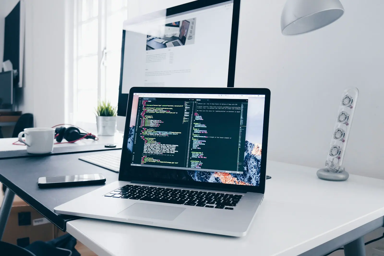 Laptop and monitor on a bright, minimal desk